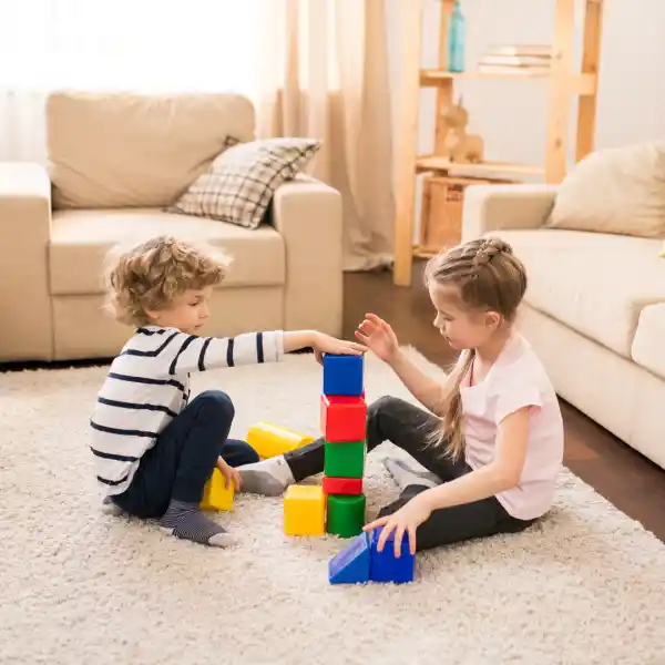 Young boy and young girl playing with blocks on the floor