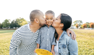 parents kissing their child 