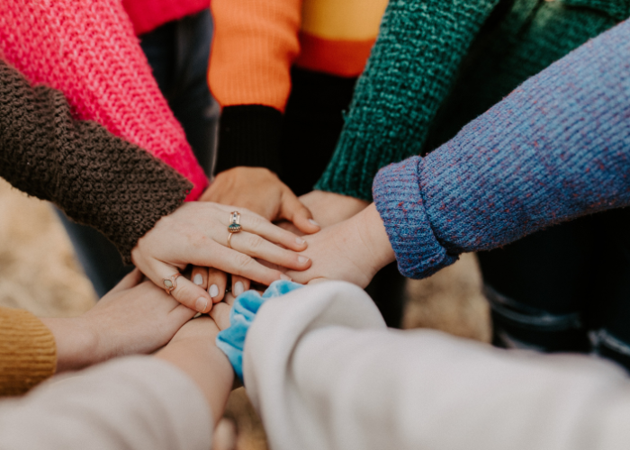 team hands in a group huddle