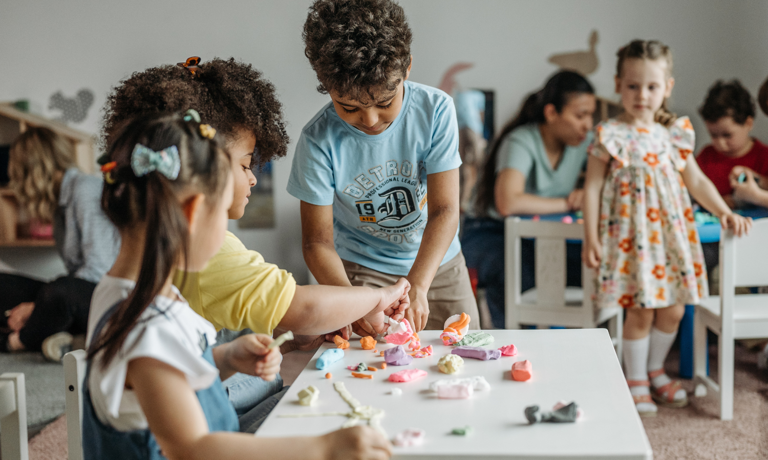 Group of children with autism working together on a playdough activity in a supportive social skills classroom.