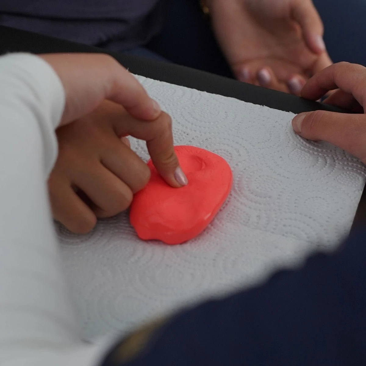 Child practicing a hands-on sensory activity with a therapist for ABA therapy near me