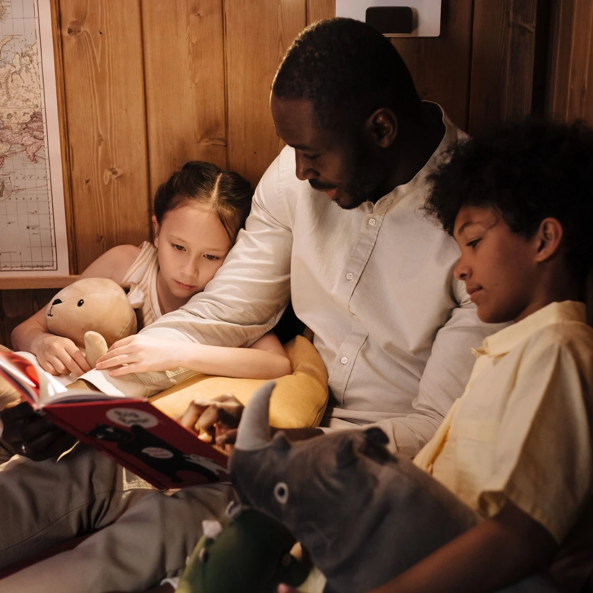 Parent reading with children during a family learning activity for family-centered ABA therapy in Lombard, IL