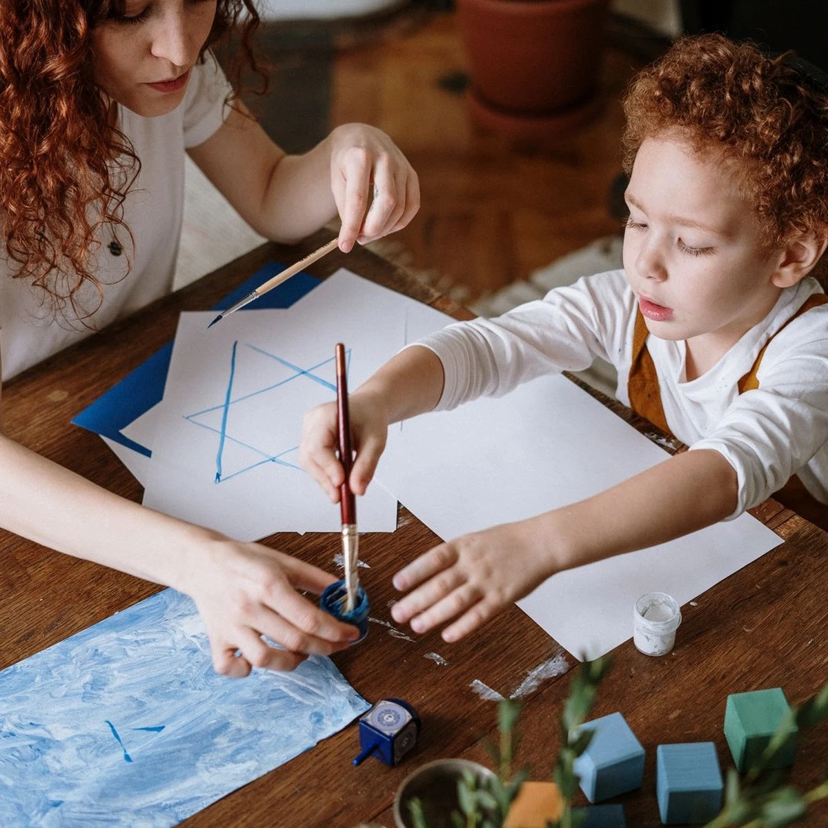 Young child practicing a guided painting activity with an adult for early intervention ABA near me